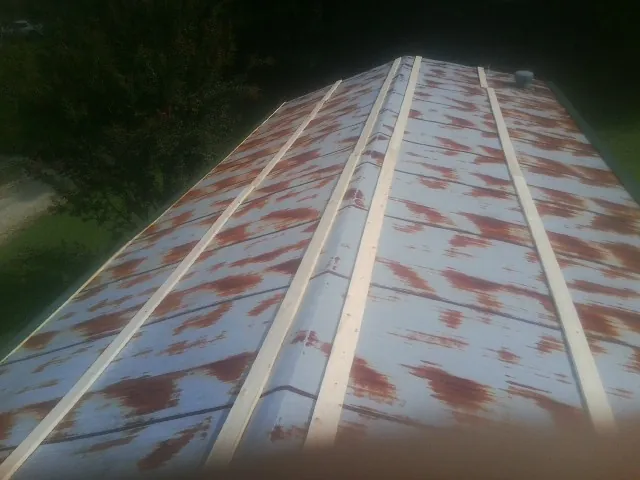 Rusted metal roof panels with new wood purlins before replacement — Storm Damage Roof Repair in Magnolia by Roofing Brothers